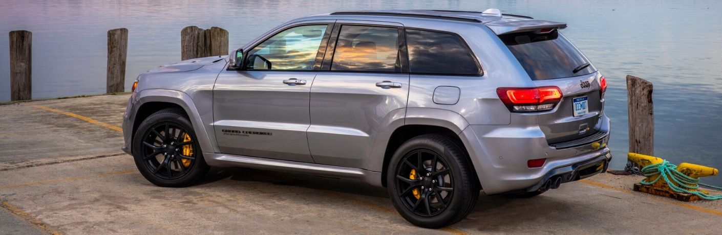 2020 Jeep Grand Cherokee parked on dock with water in background greyish paint color