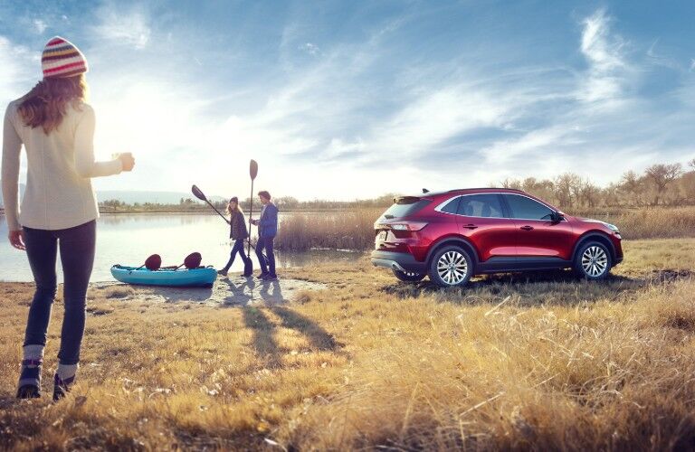 Rear passenger angle of a red 2020 Ford Escape with people getting ready to kayak