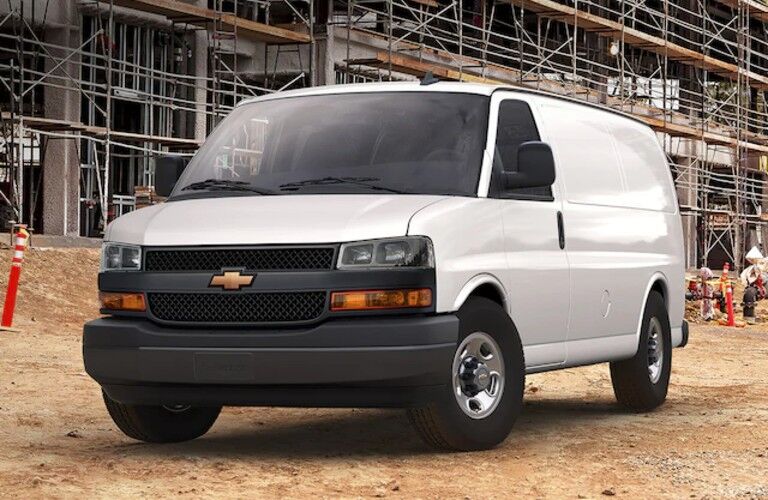 Front driver angle of a white 2020 Chevrolet Express parked at a construction site
