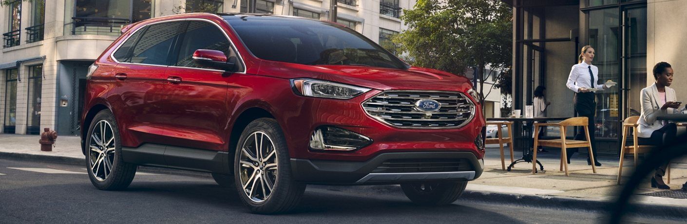 Front passenger angle of a red 2020 Ford Edge parked by a restaurant