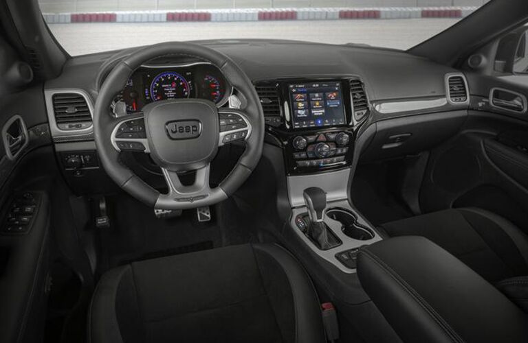 2020 Jeep Grand Cherokee interior shot of steering wheel, seating upholstery, transmission, and dashboard layout