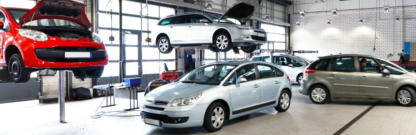 two cars in air with sedan in shop