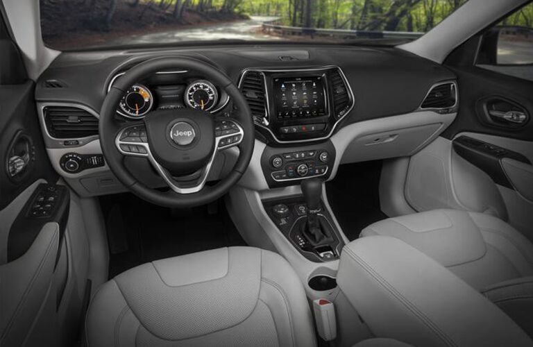 2020 Jeep Cherokee interior shot of steering wheel, seating upholstery, transmission, and infotainment dashboard setup