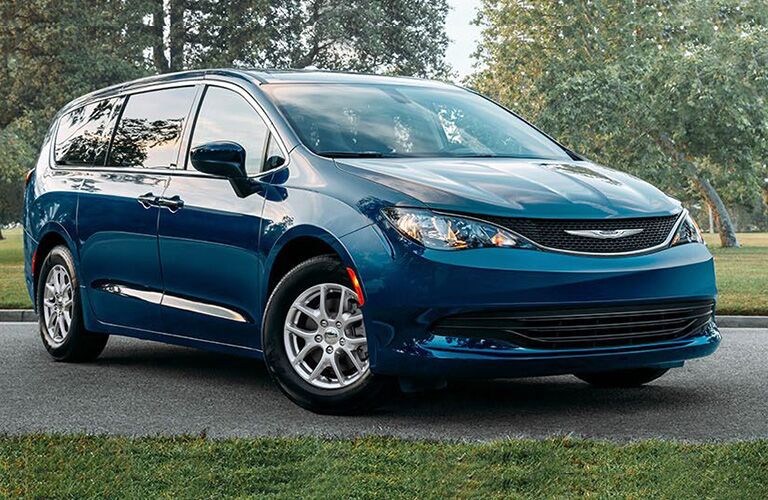 2020 Chrysler Voyager exterior shot with blue teal paint color parked on an asphalt walkway in a park with grass and green trees