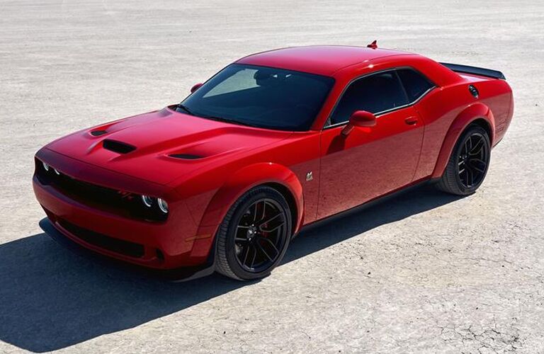 2019 Dodge Challenger exterior overhead shot with red paint color parked under the sun on a bare and cracking lot