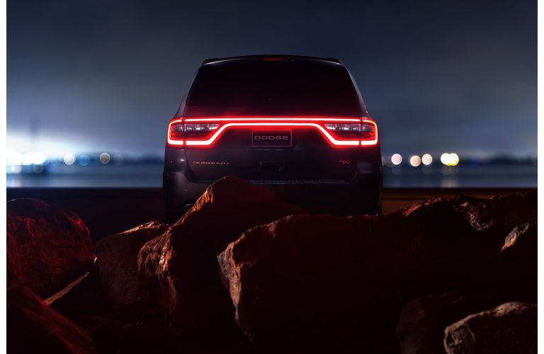 2020 Dodge Durango RT exterior rear shot with LED taillight strip let up in red and framed by a mass of red rocks and stone