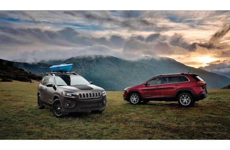 2020 Jeep Cherokee models exterior shot in silver and red parked on a grass plain as the sun sets