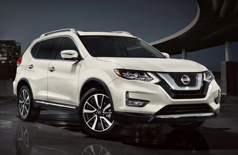 Front passenger angle of a white 2020 Nissan Rogue on a dark background