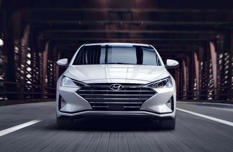 Front angle of a white 2020 Hyundai Elantra driving on a road