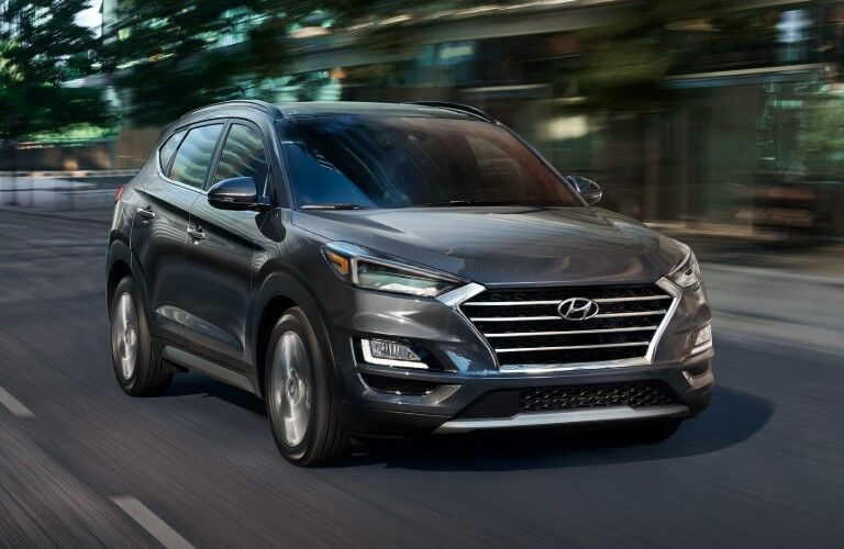 Front driver angle of a grey 2020 Hyundai Tucson driving down a road