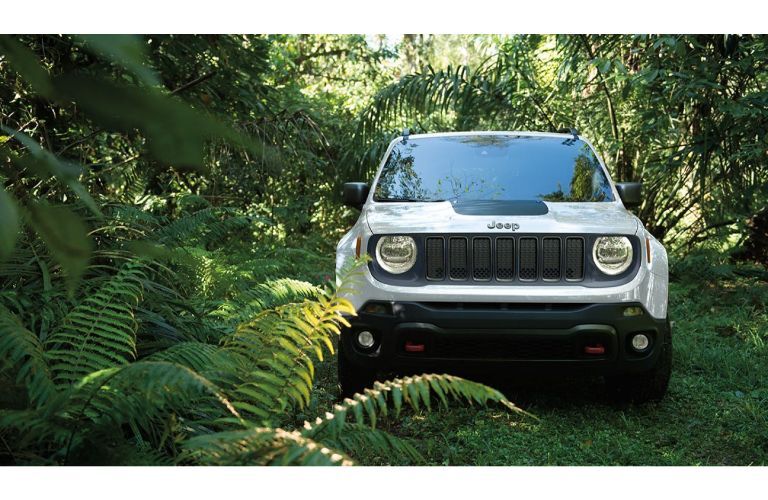 2019 Jeep Renegade exterior front shot of grille with white body paint job parked in the middle of a jungle